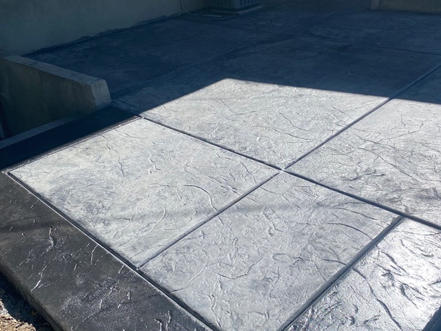 Light grey stamped concrete patio in an ashlar slate pattern