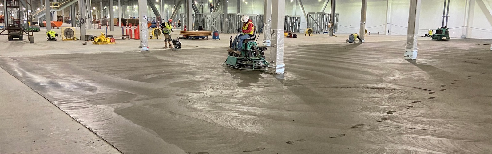 Nxgen crew power-troweling a large commercial concrete floor