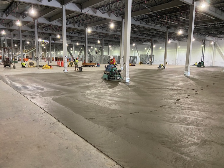 Nxgen crew power-troweling a large commercial concrete floor